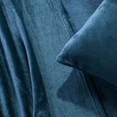 A modern bedroom with a beige upholstered bed and cream bedding exudes winter comfort, enhanced by the Morgan and Reid Winter Microplush Sheet Sets ultra-soft fabric, neutral decor, dried flowers, and light wood floors.