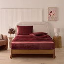 A modern bedroom with a beige upholstered bed and cream bedding exudes winter comfort, enhanced by the Morgan and Reid Winter Microplush Sheet Sets ultra-soft fabric, neutral decor, dried flowers, and light wood floors.