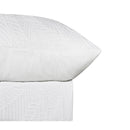 Soft textured white quilt cover creating a relaxed coastal-inspired bedroom look.