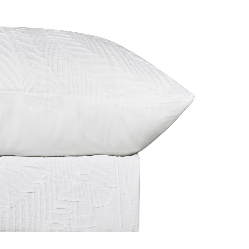 Soft textured white quilt cover creating a relaxed coastal-inspired bedroom look.