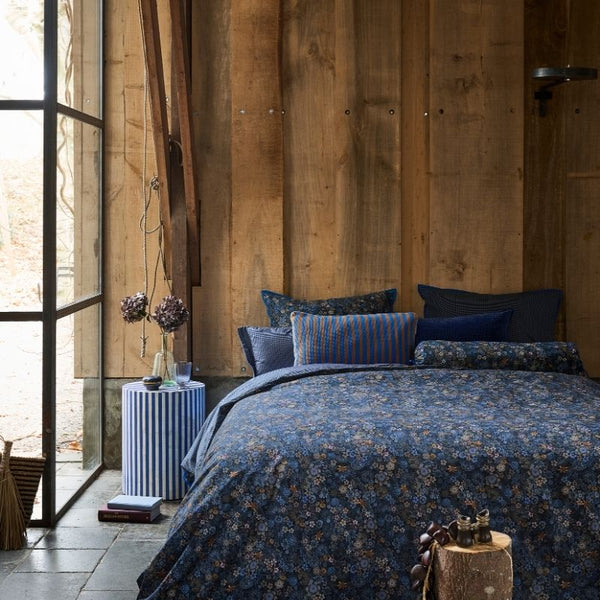 Close-up of dark blue quilt cover featuring elegant floral details.