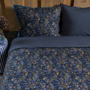 Close-up of dark blue quilt cover featuring elegant floral details.