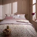 PIP Studio Garden of Dove Off-White Cushion with floral and dove design styled on bed.