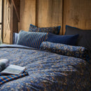 Close-up of dark blue quilt cover featuring elegant floral details.