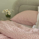 Close up spanning video of a pink checkered comforter.