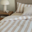 Beige stripe comforter on bed