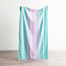 Renee Taylor Jacquard Velour Blue Cabana Beach Towel with blue, lilac, and pink stripes.