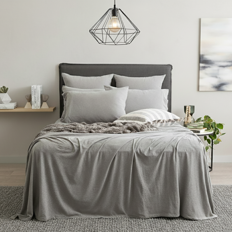 Charcoal organic cotton jersey pillowcase set styled on a soft, modern bed.
