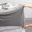 Charcoal organic cotton jersey pillowcase set styled on a soft, modern bed.