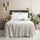 Ecru organic cotton jersey pillowcase set styled on a modern bed with soft textures.