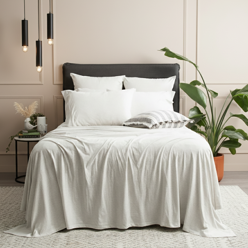 Ecru organic cotton jersey pillowcase set styled on a modern bed with soft textures.