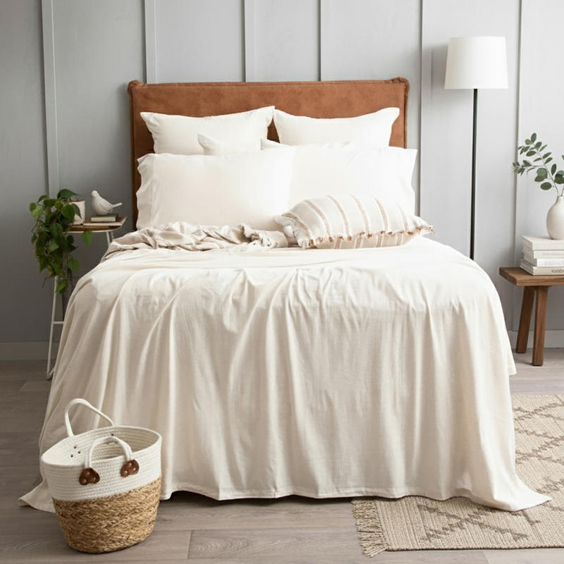 Oatmeal organic cotton jersey pillowcase set styled on a soft, neutral bed.
