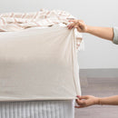 Oatmeal organic cotton jersey pillowcase set styled on a soft, neutral bed.