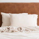 Oatmeal organic cotton jersey pillowcase set styled on a soft, neutral bed.