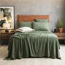 Olive organic cotton jersey pillowcase set styled on a warm-toned bed.