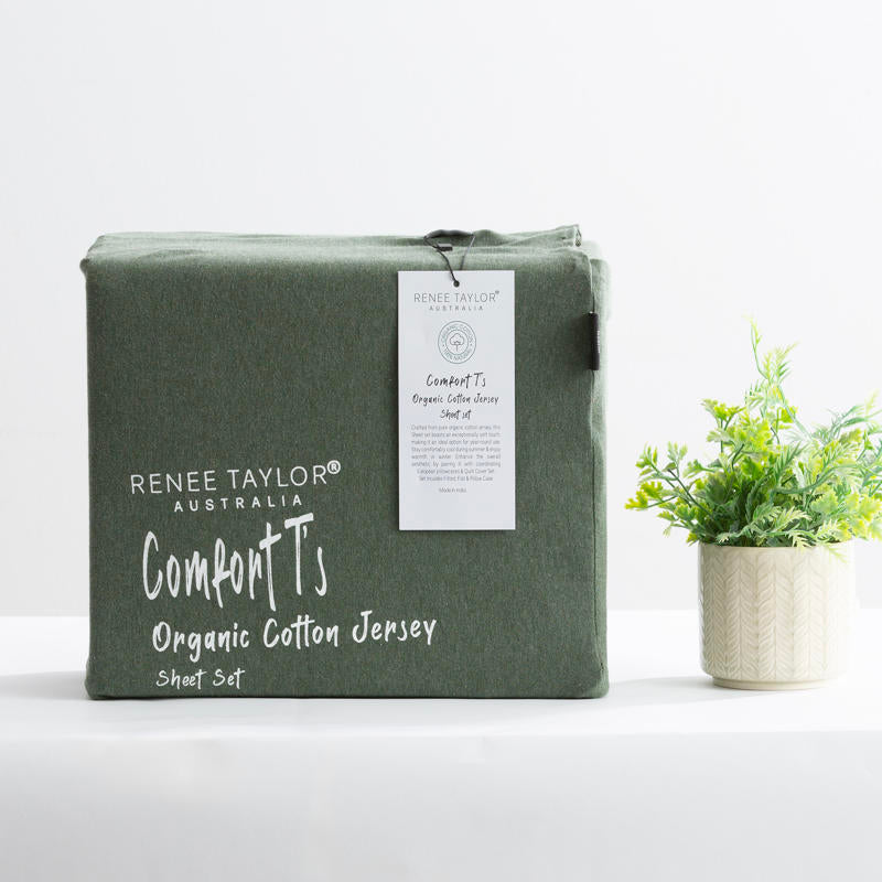Olive organic cotton jersey pillowcase set styled on a warm-toned bed.