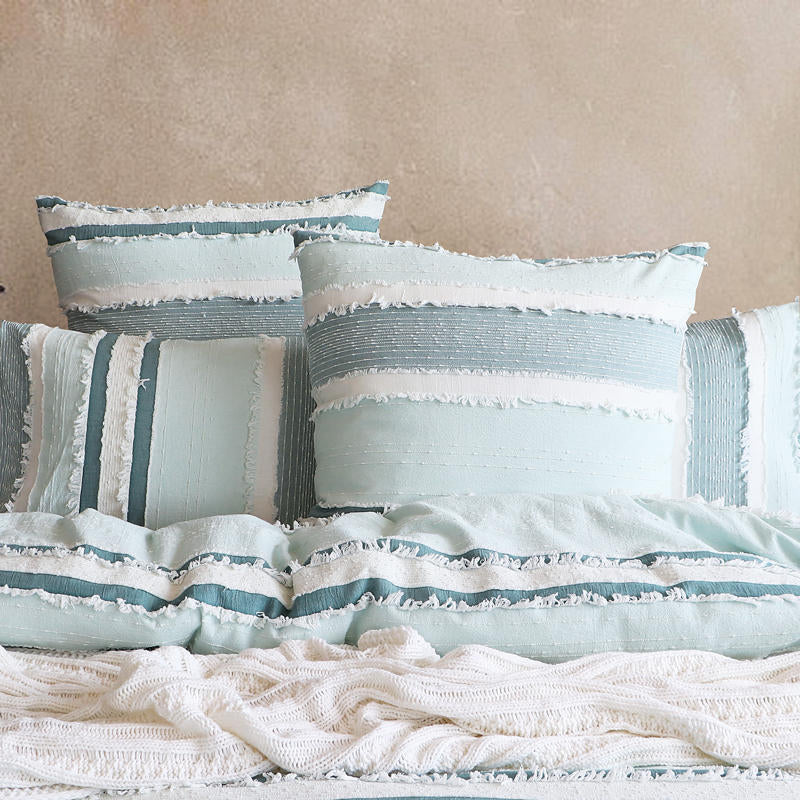 Renee Taylor Montego Quilt Cover Set styled in a coastal bedroom with ocean views.