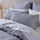 Blue and white striped linen cotton quilt cover set styled on bed with matching pillowcases.