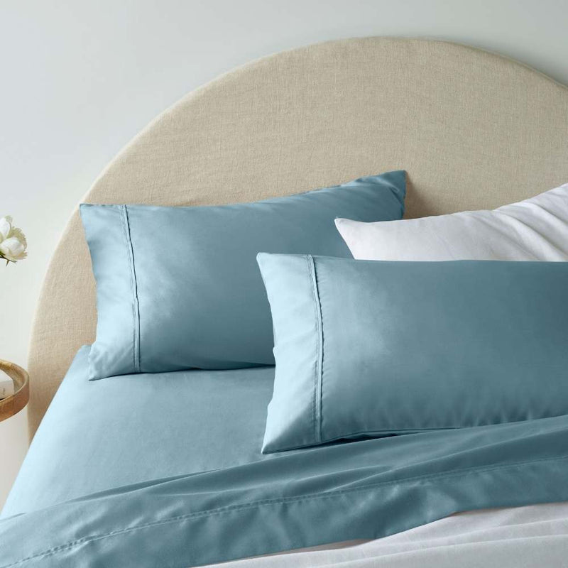 "A blue, superior-quality cotton sheet set in a cosy bedroom"