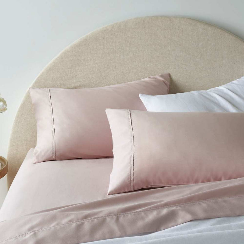 "A pink, superior-quality cotton sheet set in a cosy bedroom"