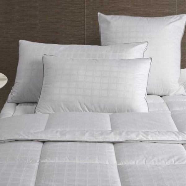 alt="A fine quilt enhanced with a sophisticated 375 thread count cotton cover with piped edge in a cosy bedroom"