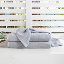 alt="Light blue soft cotton bath towel in the wooden chair"