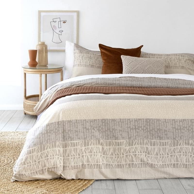 alt="Geometric quilt cover set in cosy bedroom"