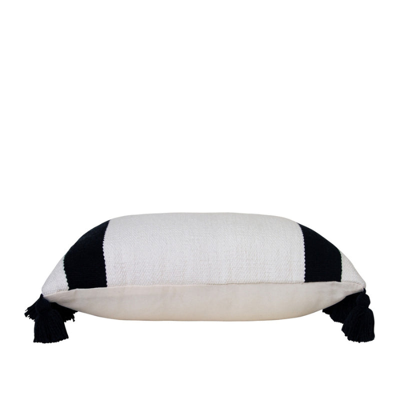 alt="Side details of an ivory cushion featuring a block-coloured design with two thick solid black stripes and with two sides of chunky tassels"