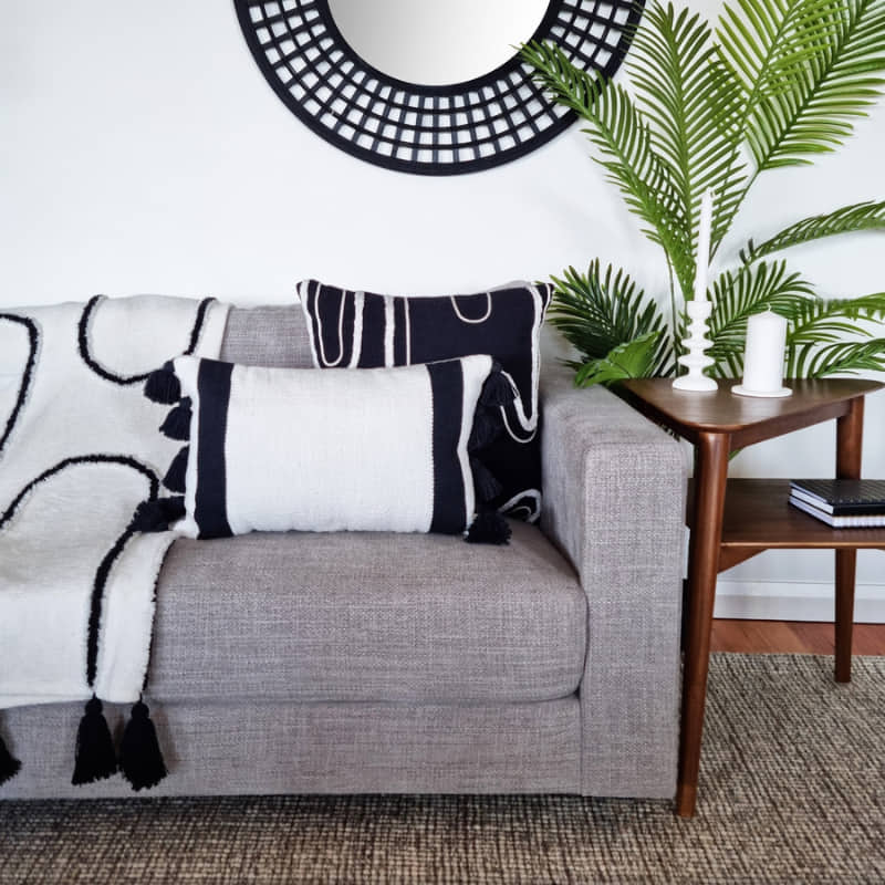 alt="A perfect combination of black and white cushions, sitting together to make a bold statement in a living space"