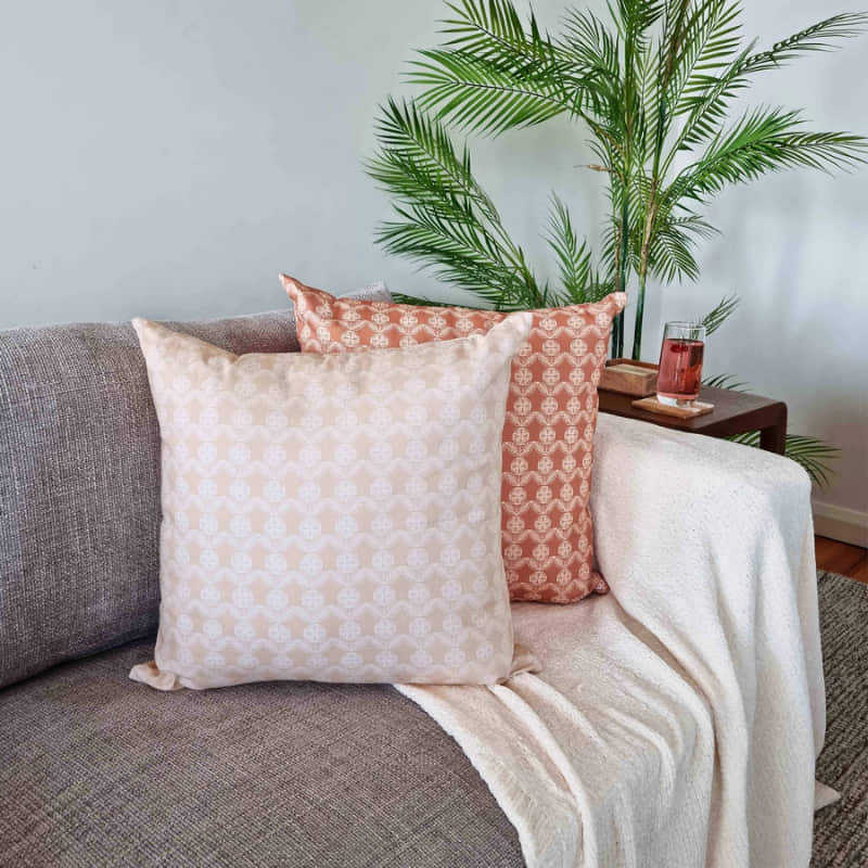 alt="A natural cushion featuring a rustic boho design printed in a sofa"