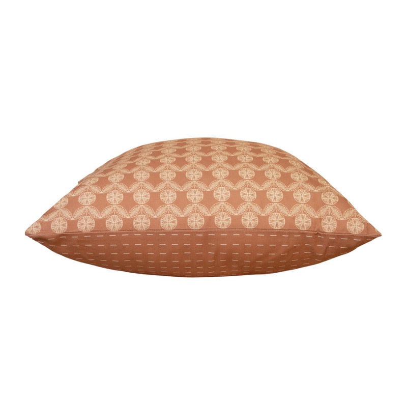 alt="Side details of a brown cushion featuring a rustic boho design printed"