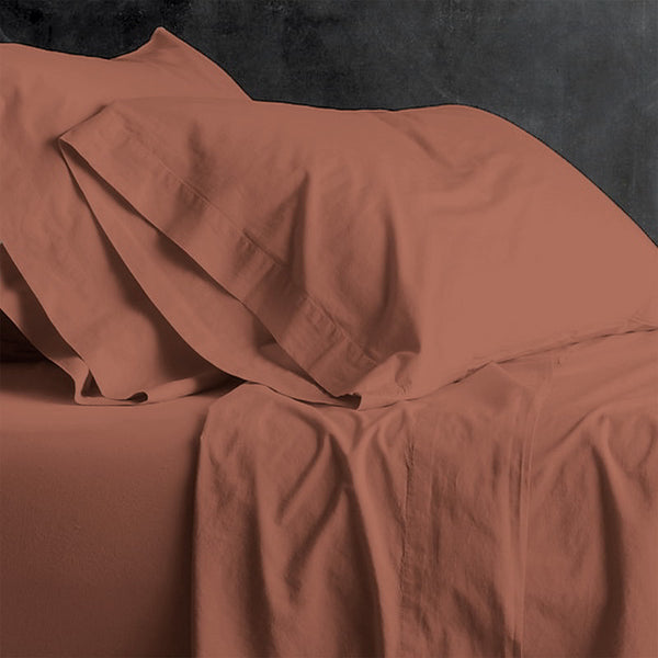 alt="An orange plain sheet set featuring an ultra-soft, velvety texture in a luxurious bedroom"