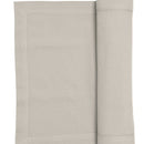 An oatmeal runner elegantly folded, enhancing the sophistication of the dining experience.