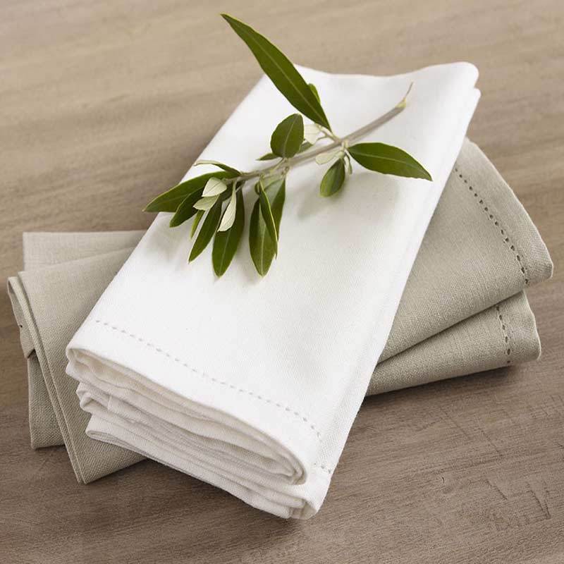 A stack of napkins adorned with olive leaves, enhancing the elegance of a refined dining setting.