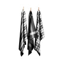 Three black tea towels hanging on clotheslines, showcasing elegant designs and absorbent cotton for kitchen utility.
