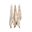 Three taupe tea towels hanging on clotheslines, showcasing elegant designs and absorbent cotton for kitchen utility.