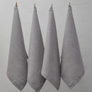 Four grey napkins hanging on a clothesline, exemplifying elegance and versatility in home textiles.
