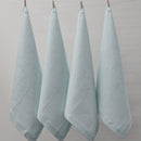 Four mist napkins hanging on a clothesline, exemplifying elegance and versatility in home textiles.
