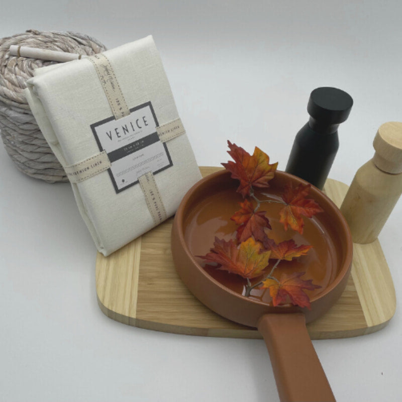 Packaging details of Venice white linen napkins accompanied by a wooden tray and kitchen things, perfect for an elegant table arrangement.