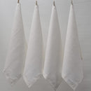 Four white napkins hanging on a clothesline, exemplifying elegance and versatility in home textiles.