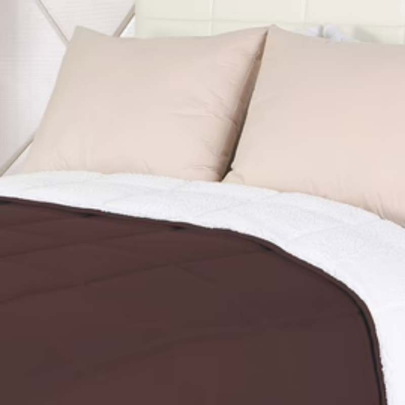 Close up details of the elegant brown comforter on a bed; the reversible design provides warmth and style, making it ideal for chilly nights.