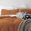 alt="A cosy bed with an orange quilt cover and pillows, adorned with the Vintage Washed Cotton Blush Quilt Cover Set for a stylish and comfortable bedroom."