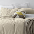 alt="A cosy bed with shade of stone quilt cover and pillows, adorned with the Vintage Washed Cotton Blush Quilt Cover Set for a stylish and comfortable bedroom."